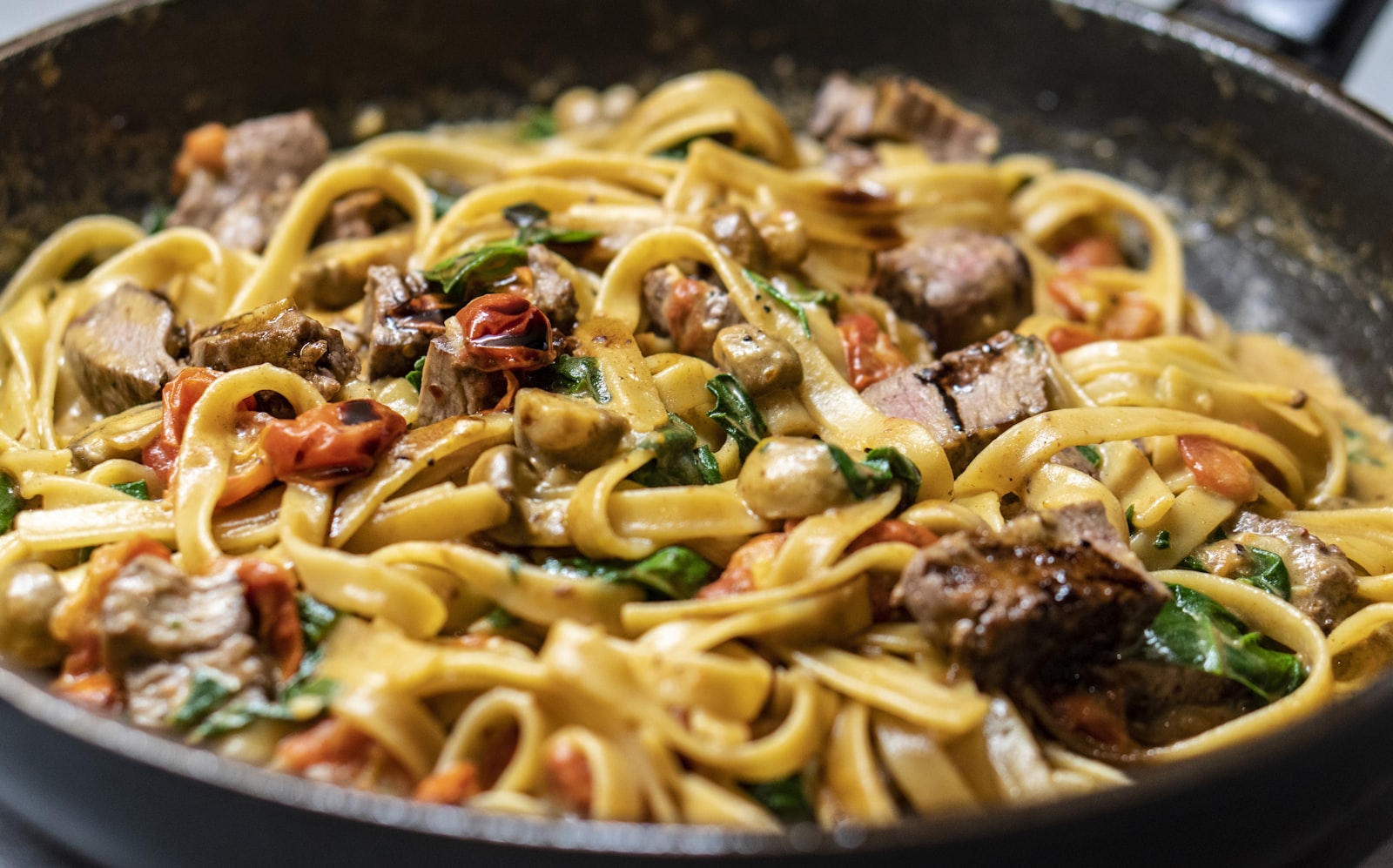 A plate of spaghetti tossed with bright green pesto, grated Parmigiano on top